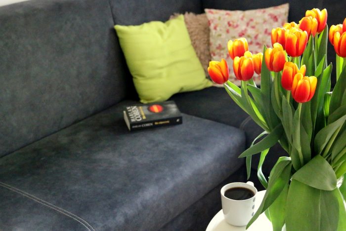 tulipany, kawa, książka na kanapie